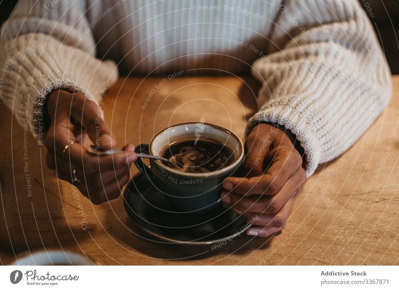 Anonyme Frau mit Kaffeetasse im Café Tasse Hand Erwachsener Person Sitzen genießend frisch heiß gebraut Becher trinken Getränk schwarz Tisch hölzern Kantine