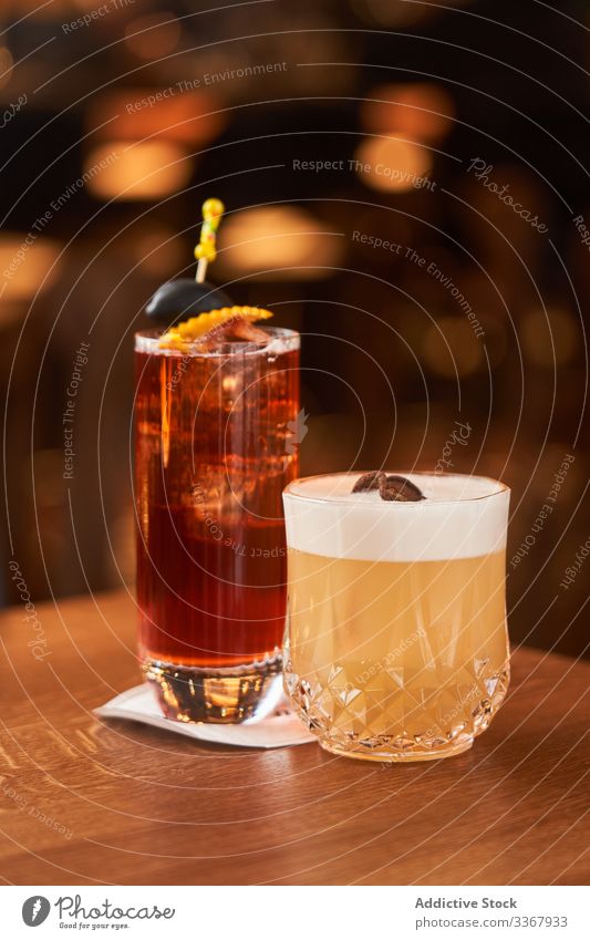 Roter Alkoholcocktail mit schwarzer Olive und Whiskey-Zitronen-Cocktail trinken klassisch rot Glas hochball Eis oliv Abfertigungsschalter Bar kalt Aperitif