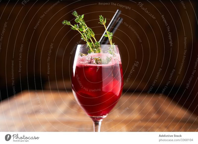 Stilvoll servierter Alkoholcocktail mit Rosmarin Cocktail trinken Getränk Bar gemischt Beeren rot Tube Restaurant Glas Erfrischung liquide kalt Kraut Abend