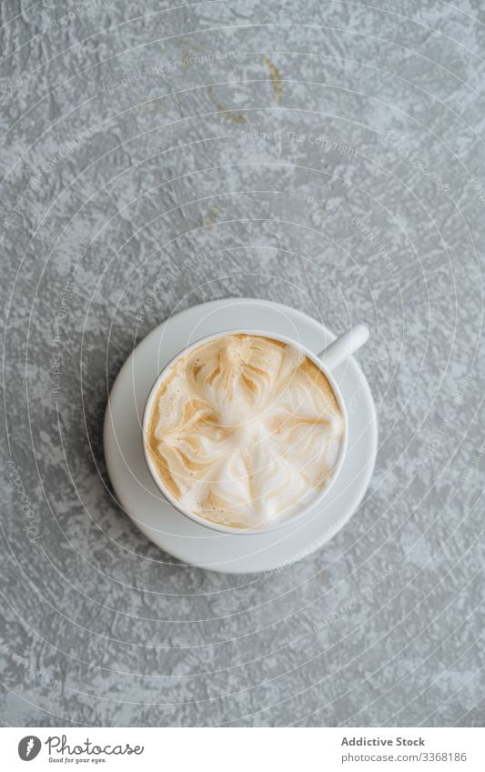 Tasse Cappuccino auf grau strukturiertem Hintergrund Kaffee Kunst Latte trinken heiß Getränk Untertasse Bierschaum schäumen Frühstück Café Morgen Koffein Pause
