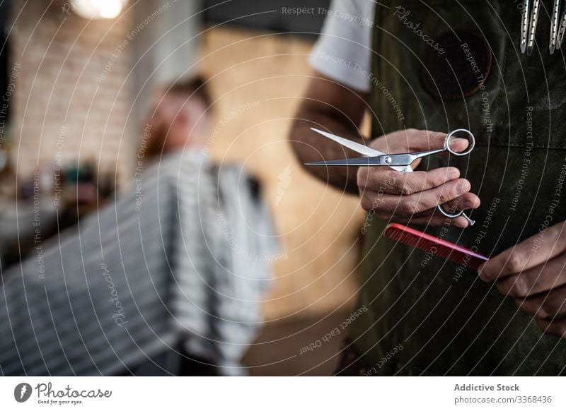 Anonymer Friseur mit Schere und Kamm Klient trendy Barbershop bärtig Maskulinität Mann Kunde Behaarung Pflege Salon Hipster gutaussehend stylisch entspannend