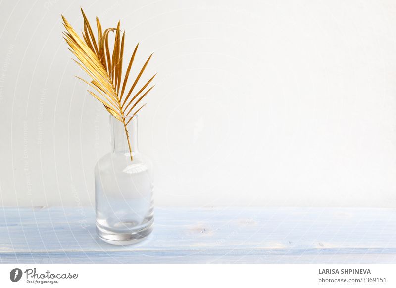 Goldenes Palmenblatt in Glasvasenflasche auf hellem Hintergrund Flasche Reichtum elegant Stil Design exotisch schön Dekoration & Verzierung Tisch Natur Pflanze