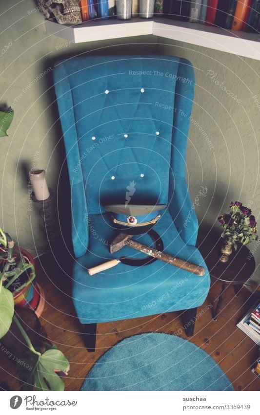 hammer, sichel, totenkopf auf türkisfarbenem sofa in gemütlicher wohnzimmerecke Fotochallenge Hammer Sichel Totenkopf Schädel Sofa Werkzeug Politik & Staat