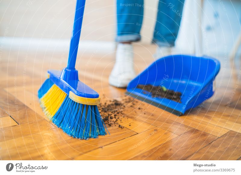 Lateinamerikanischer Mann kehrt zu Hause den Holzboden mit Besen. ausladend Stock heimwärts Hausarbeit Haushalt Haushälterin Objekt im Innenbereich Gerät lebend