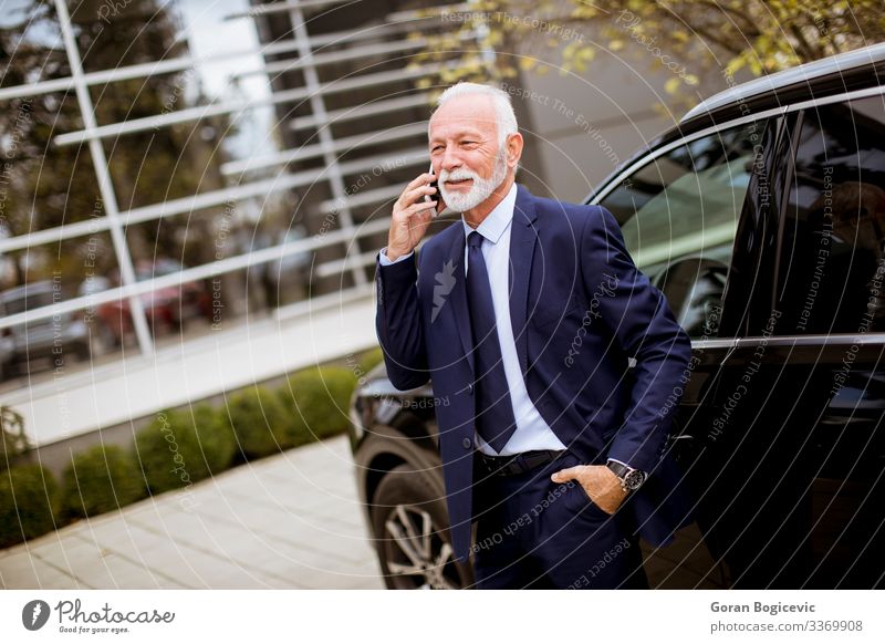 Leitender Geschäftsmann benutzt Mobiltelefon in der Nähe des Autos Lifestyle Reichtum Ferien & Urlaub & Reisen Dekoration & Verzierung Business sprechen Telefon