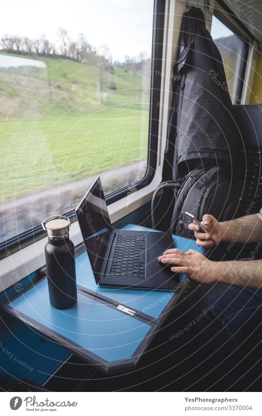 Mann benutzt Laptop und Telefon im Zug. Schweizer Zuginnenraum Ferien & Urlaub & Reisen Tourismus Ausflug Stuhl Tisch Arbeit & Erwerbstätigkeit Verkehr