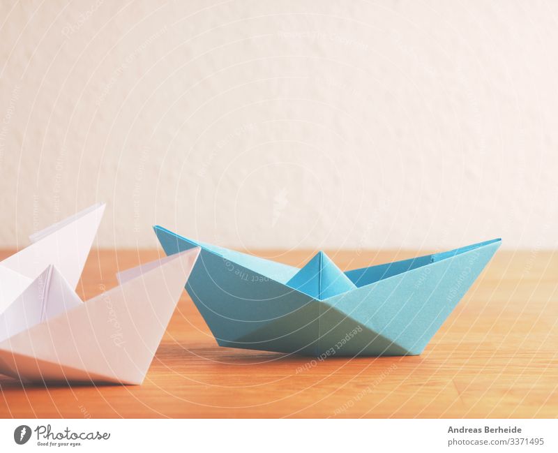 Teamwork-Geschäftskonzept mit Papierboot auf einem Holztisch Hintergrund blau Boot Business Farbe Kompass Konkurrenz Konzept Textfreiraum kreativ Kreativität