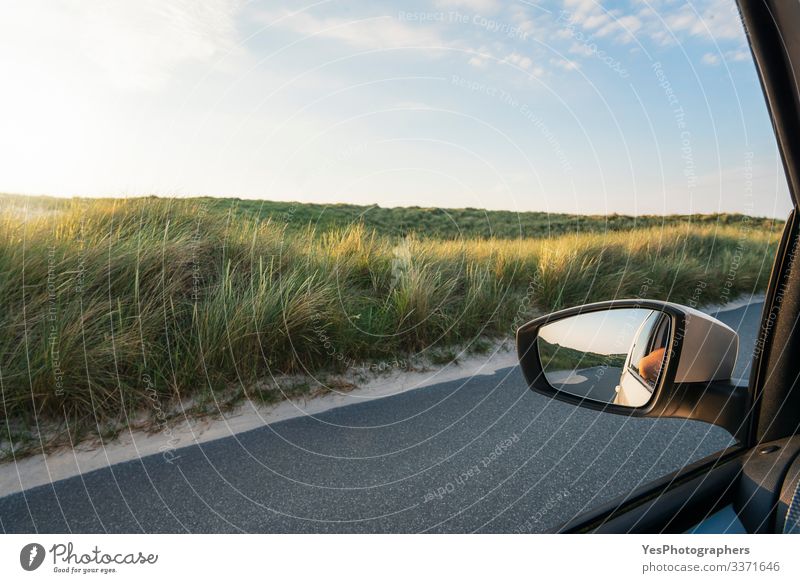 Autofensteransicht mit Grasdünen und Straße auf der Insel Sylt Ferien & Urlaub & Reisen Tourismus Ausflug Sommer Spiegel Landschaft fahren Perspektive