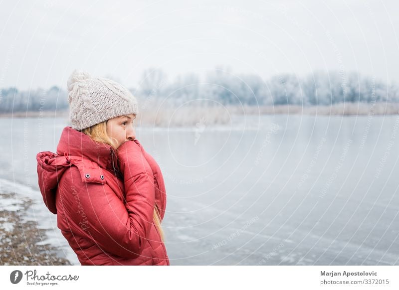 Junge Frau steht im Winter am zugefrorenen See Lifestyle Abenteuer wandern feminin Jugendliche Erwachsene 1 Mensch 30-45 Jahre Umwelt Natur Landschaft Wasser
