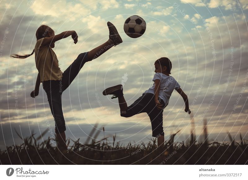 Fröhliche kleine Jungen und Mädchen spielen auf dem Spielfeld mit Fussball. Kinder, die im Freien Spaß haben. Konzept des Sports. Lifestyle Freude Glück