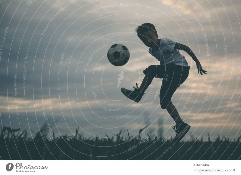 Kleiner Junge spielt auf dem Feld mit einem Fussball. Begriff des Sports. Lifestyle Freude Glück Erholung Freizeit & Hobby Spielen Sommer Fußball Kind Mensch