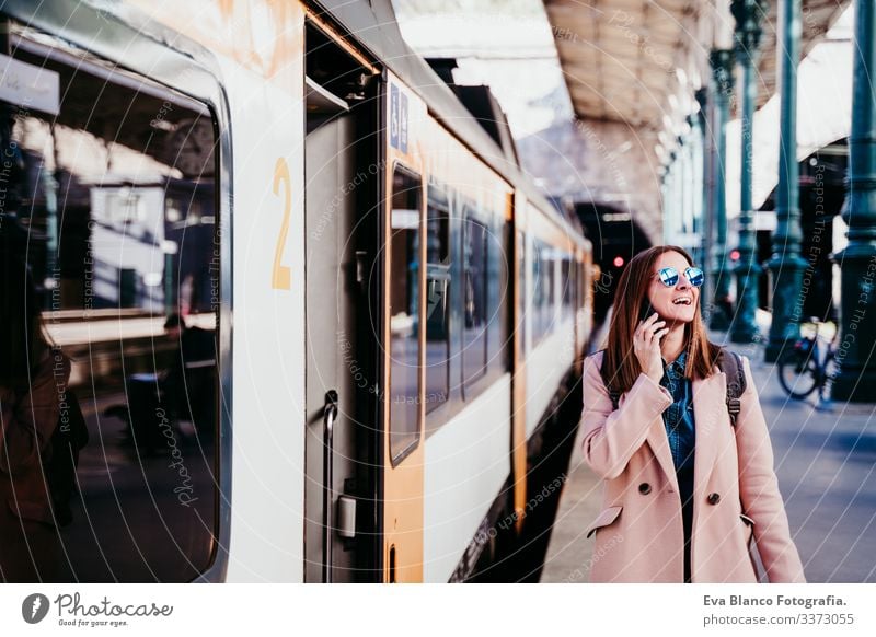 junge Frau am Bahnhof, die ein Mobiltelefon benutzt. Reisekonzept Bildschirm Ausflugsziel reisen Rucksack Kaukasier Europa Eisenbahn Warten Wagen Schiene