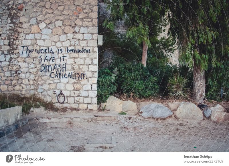 Mauer mit Schriftzug: Die Welt ist wunderschön, rette sie, zerstöre Kapitalismus Tag Menschenleer Außenaufnahme Farbfoto Wirtschaftskrise nachhaltig