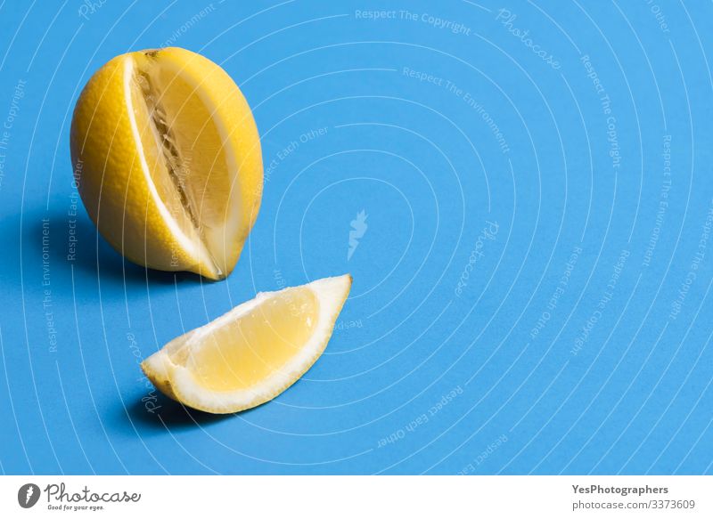 Reife Zitrone und eine Zitronenscheibe. Zitrusfrüchte. Frisches Obst Frucht Gesunde Ernährung frisch Blauer Hintergrund farbenfroh Textfreiraum Lebensmittel