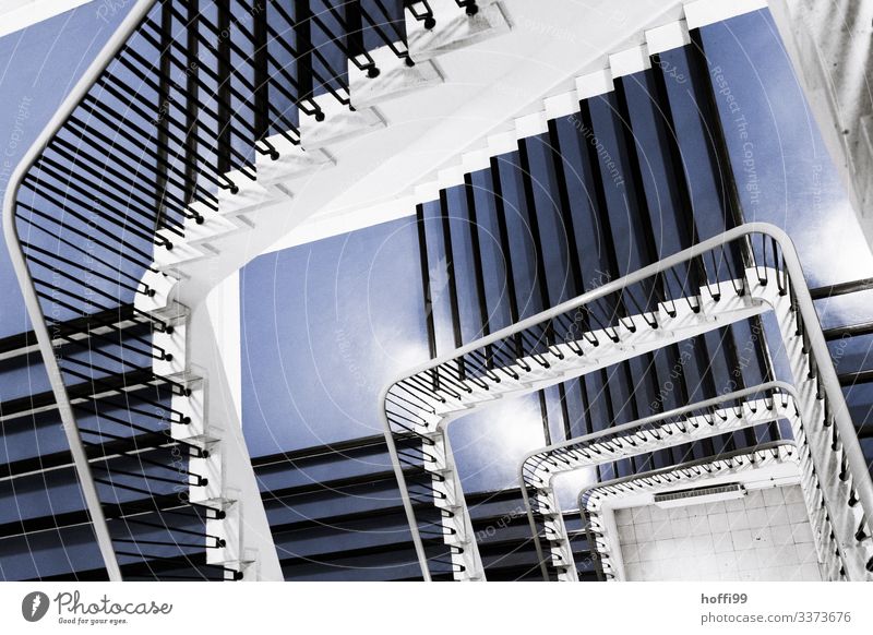 Blick von oben in ein Treppenhaus Blick nach unten Innenaufnahme treppenschacht Geländer Wendeltreppe Treppengeländer ästhetisch Menschenleer blaue Treppe