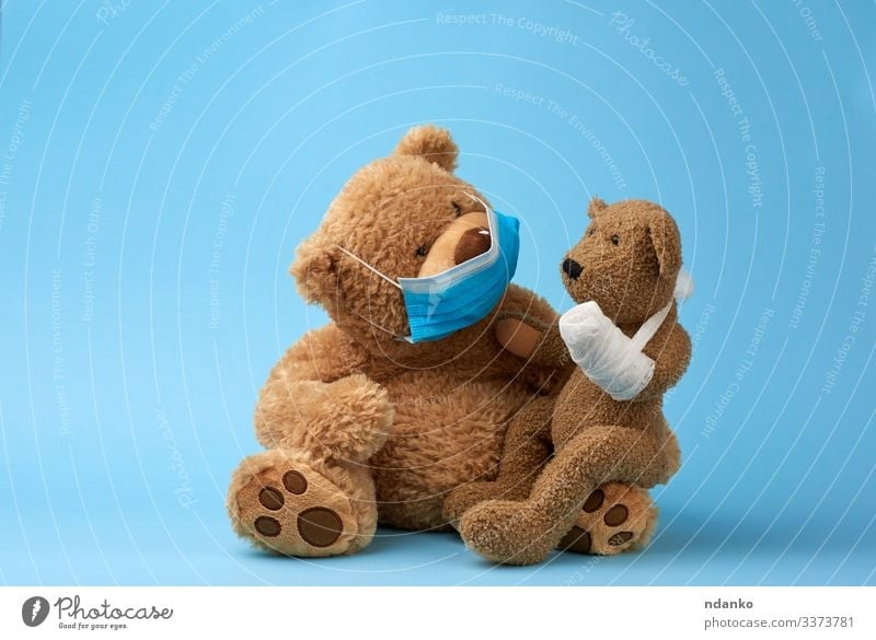 großer brauner Teddybär sitzt in einer medizinischen Maske Freude Krankheit Medikament Krankenhaus Baby Kindheit Tier Pfote Spielzeug Puppe Traurigkeit klein