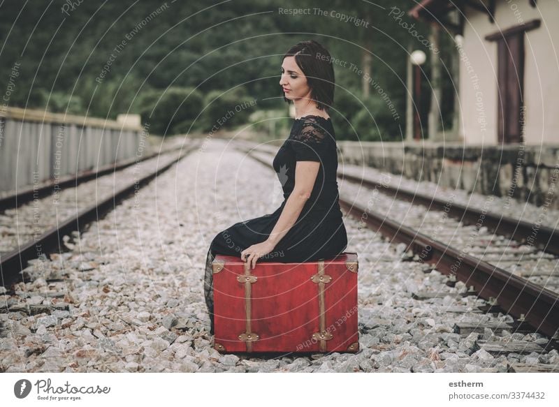 junge Frau, die auf einem Koffer auf dem Bahnhof sitzt Junge Frau schön elegant Eleganz romantisch Zerbrechlichkeit Liebe Weiblichkeit Kleid Nostalgie Freiheit
