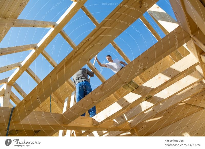 Bauarbeiter bei der Arbeit mit hölzerner Dachkonstruktion. Haus Rahmen heimwärts Bauherr Konstruktion Zimmerer Holz Dachdecker Arbeiter Gebäude Entwicklung