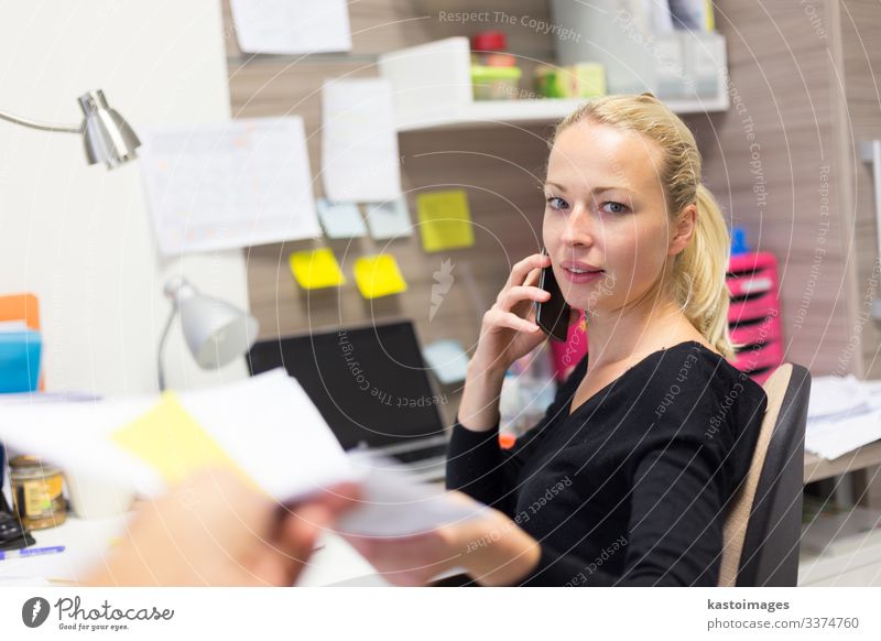 Geschäftsfrau, die mit dem Handy telefoniert und Papiere entgegennimmt. Glück Schreibtisch Tisch Arbeit & Erwerbstätigkeit Beruf Büroarbeit Arbeitsplatz