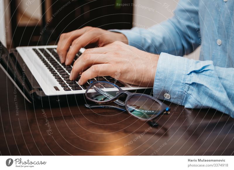 Geschäftsmann beim Tippen am Computer-Laptop im Büro mit Brille auf dem Tisch Notebook Keyboard Technik & Technologie Fortschritt Zukunft Mann Erwachsene Hand