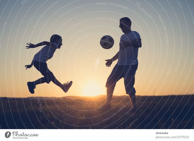 Vater und kleiner Junge spielen auf dem Feld mit einem Fussball. Begriff des Sports. Lifestyle Freude Glück Leben Freizeit & Hobby Spielen Sommer Fußball Kind