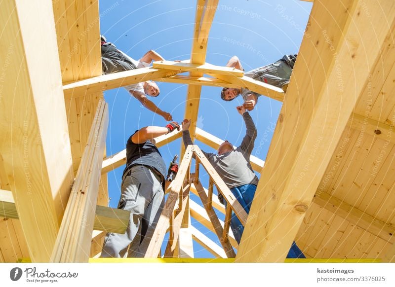 Dachdecker, die vorgefertigte Holzdachkonstruktionen montieren. Konzept der Bauindustrie. Haus Arbeit & Erwerbstätigkeit Handwerker Baustelle Industrie Werkzeug