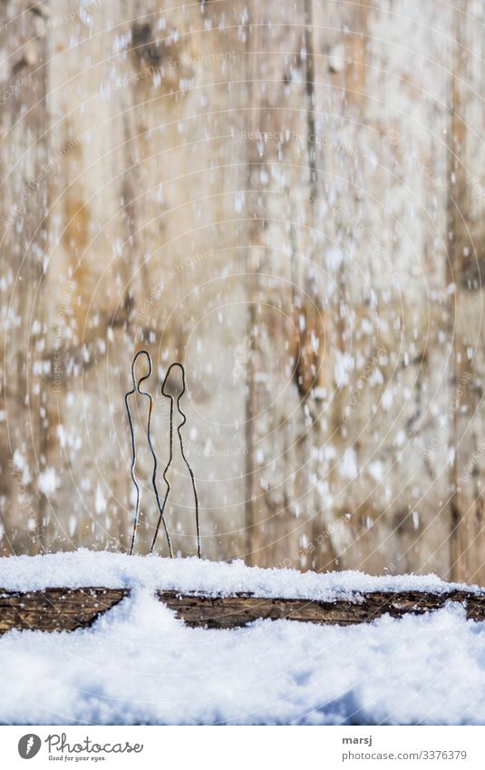 Ein Paar macht einen Spaziergang bei Schneefall über ein schneebedecktes Brett Zentralperspektive Kontrast Licht Textfreiraum oben Nahaufnahme Gedeckte Farben