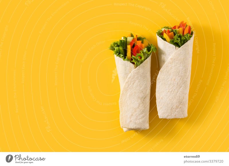 Gemüsetortilla-Wraps auf gelbem Hintergrund. Kopierbereich in der Draufsicht burrito Möhre Salatgurke Diät fajita Lebensmittel frisch grün Gesundheit vereinzelt