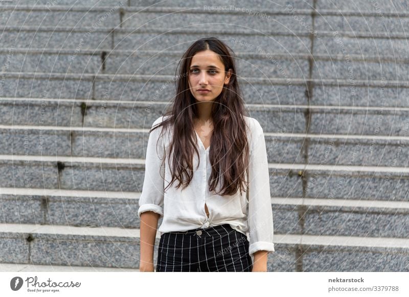 Junge Schönheit aus dem Nahen Osten blickt mit neutralem Gesichtsausdruck Frau Mädchen Stehen junger Erwachsener Jugendkultur Tag urban schöne Frau