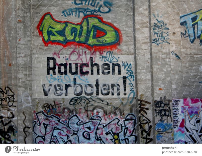 Aufschrift „Rauchen verboten“ auf Gebäudewand mit Graffiti rauchen aufschrift gebäude bunt außenaufnahme wörter hinweis Gefahr Zigarette Verbote Gesundheit