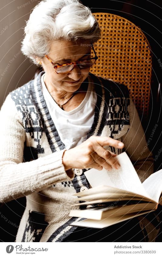 Ältere Frau liest mit Begeisterung am Fenster lesen Buch älter Wissen Literatur Konzentration Information intelligent klug kreativ Brille sich[Akk] entspannen