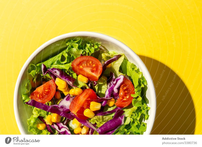 Frischer Kopfsalat mit Kirschtomaten Salatbeilage Lebensmittel Salatkopf Mais rote Zwiebel Sonnenlicht frisch Gemüse Veganer Vegane Ernährung gesunde Ernährung