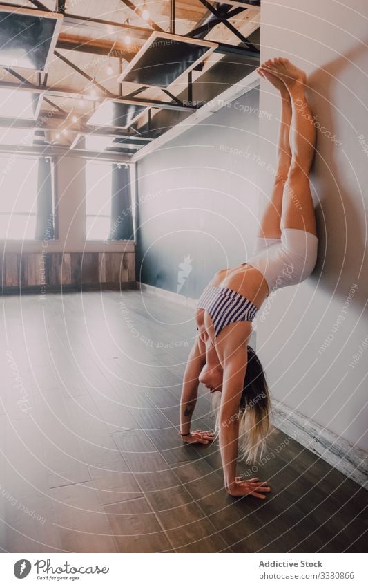 Starke, fitte Frau macht Handstandübung in leichter, moderner Turnhalle akrobatisch Training Übung Yoga Gleichgewicht Fitnessstudio