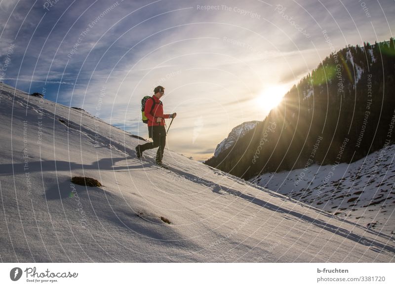 Frau mit Wanderrucksack und Wanderstöcke im Gebirge, schneebedeckte Landschaft im Winter. berge gebirge sonnenuntergang alpen Berchtesgadener Alpen Spuren
