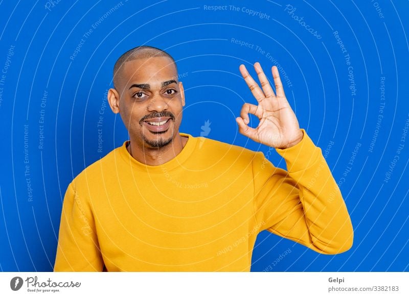Afrikaner mit gelbem Trikot schwarz Typ blau OK akzeptieren ja Glück Lächeln lustig Seufzer Finger Hand Erwachsener Menschen Person Afrikanisch männlich