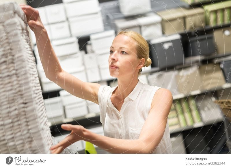 Hübsche junge Frau beim Einkaufen im Einzelhandelsgeschäft. Werkstatt Käufer heimwärts Kasten Möbel Erwachsener Laden Wahl Design Glück Blick Verbraucher