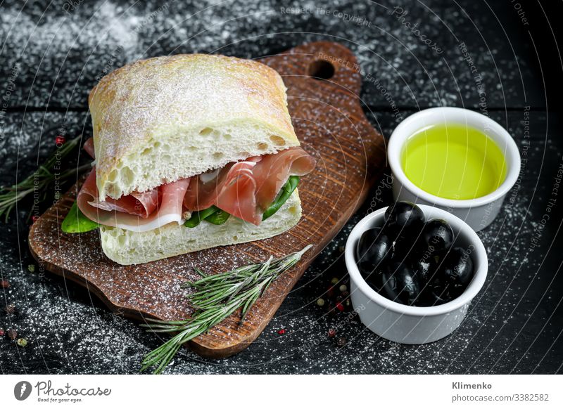 Ciabatta-Sandwich mit Rucolasalat, Blattspinat und Speck. Salatbeilage Spinat Belegtes Brot Oliven Rosmarin Erdöl Olivenöl Italien Bruschetta Lebensmittel Mehl