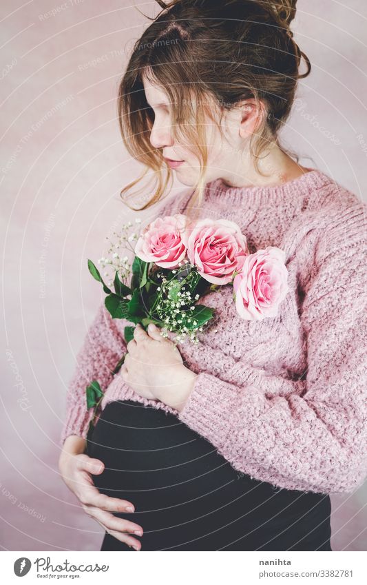 Junge schwangere Frau mit einem Rosenstrauss Schwangerschaft Mama Warten Familie Liebe drittes Trimester Monat Wochen natürlich wirklich offen echte Frau