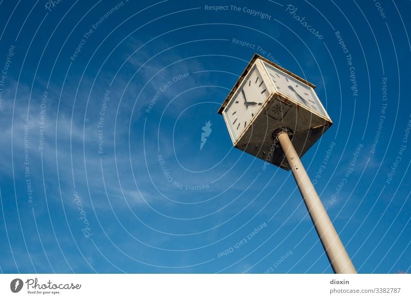 Alte, defekte Stadtuhr, die zwei verschiedene Zeiten vor einem blauen Himmel mit weißen Schleierwolken anzeigt Uhr Uhrenzeiger Zeitpunkt Ziffern & Zahlen
