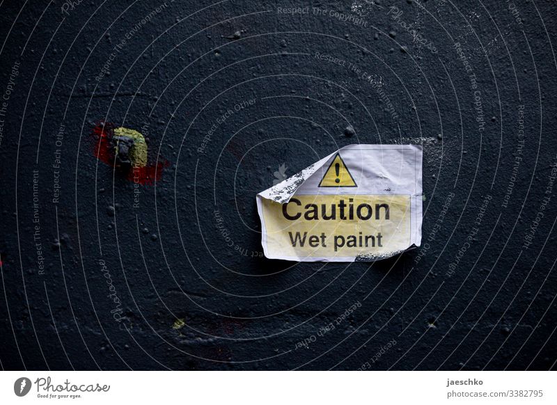 Hinweisschild "Caution - wet paint" an einer Wand Farbe frisch gestrichen streichen feucht Warnung Warnschild Malerarbeiten Bauarbeiten Renovierung renovieren