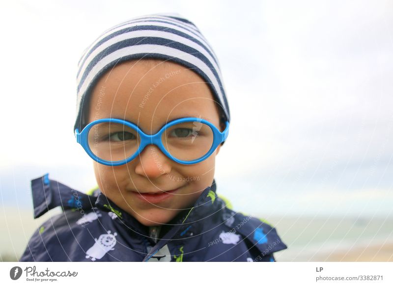 hübsches Kind mit Brille, das in die Kamera schaut Achtsamkeit Kinderspiel Kindheitserinnerung Kinderwunsch Kindheitstraum Inokenz Glück, Emotionen Gefühl