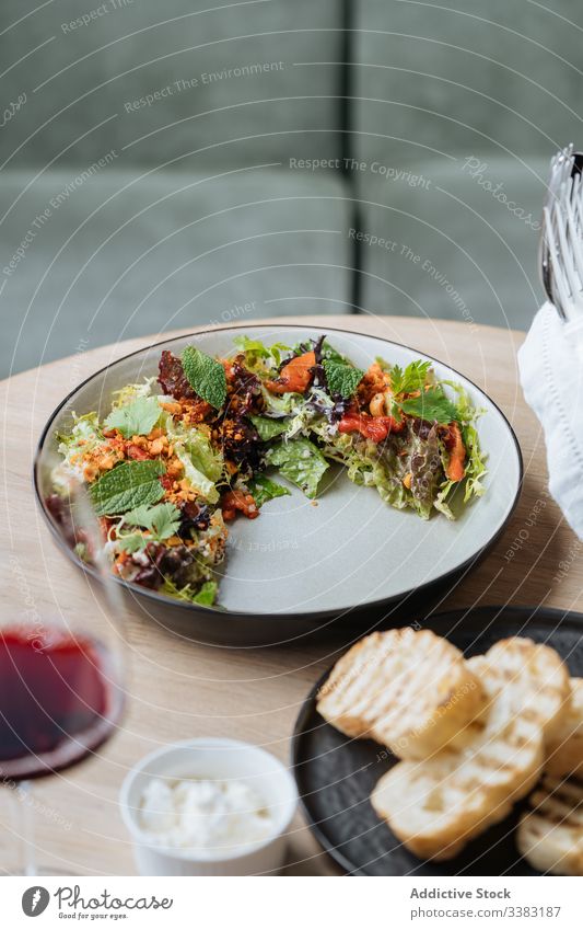 Salat der gehobenen Küche mit Meeresfrüchten und Brot im Restaurant Salatbeilage Haute Cuisine Teller Speise Octopus Tomaten gebraten Scheibe Spielfigur