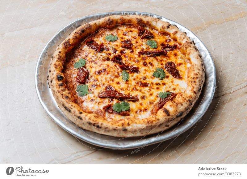 Frische Pizza mit Käse und getrockneten Tomaten im Restaurant Speise Lebensmittel Mahlzeit geschmackvoll Tradition Italienisch Mittagessen lecker Küche rund