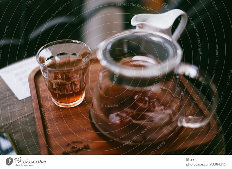 Eine Kaffeekanne mit einem Glas voller Kaffee auf einem Tablett aus Holz in einem Café holz retro kaffeepause aromatisch Morgen Getränk Koffein altehrwürdig