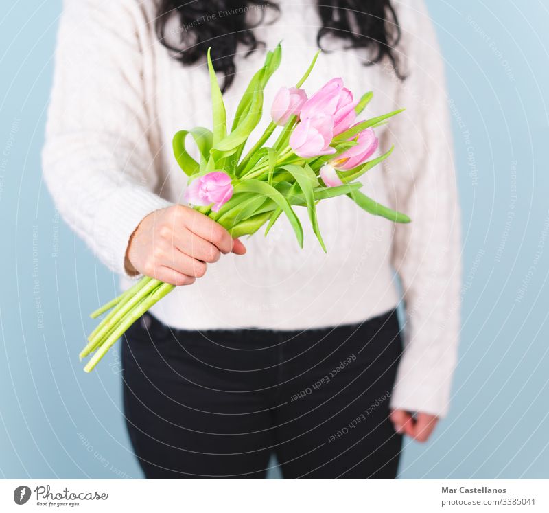 Frau in einem weißen Pullover mit einem Strauß rosa Tulpen. Frühjahrskonzept. Mutter Liebe romantisch Valentinsgruß Glamour Gruß präsentieren Hochzeit