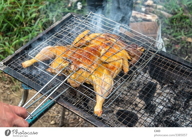 Leckeres ganzes Huhn im Freien gegrillt Outdoor-Küche Koch versuchen Sie zu kochen Barbecue grillen Picknick mögen Sie Würstchen auskochen Barbecue-Ofen