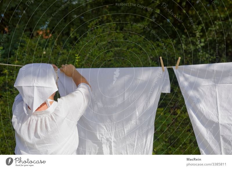 Waschfrau aufhängen altmodisch bleichen draussen garten historisch klammer klammern kopftuch korb leine retro waschen waschfrau waschtag wäsche wäscheleine