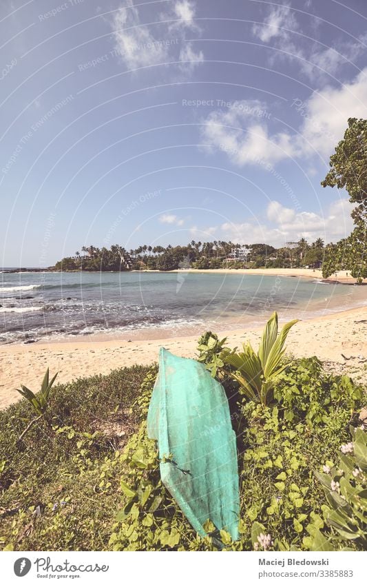 Retrofarbenes, stilisiertes Bild eines tropischen Strandes mit einem kleinen Boot. Sommer retro Instagrammeffekt gefiltert Sonne MEER Meer Urlaub Feiertag