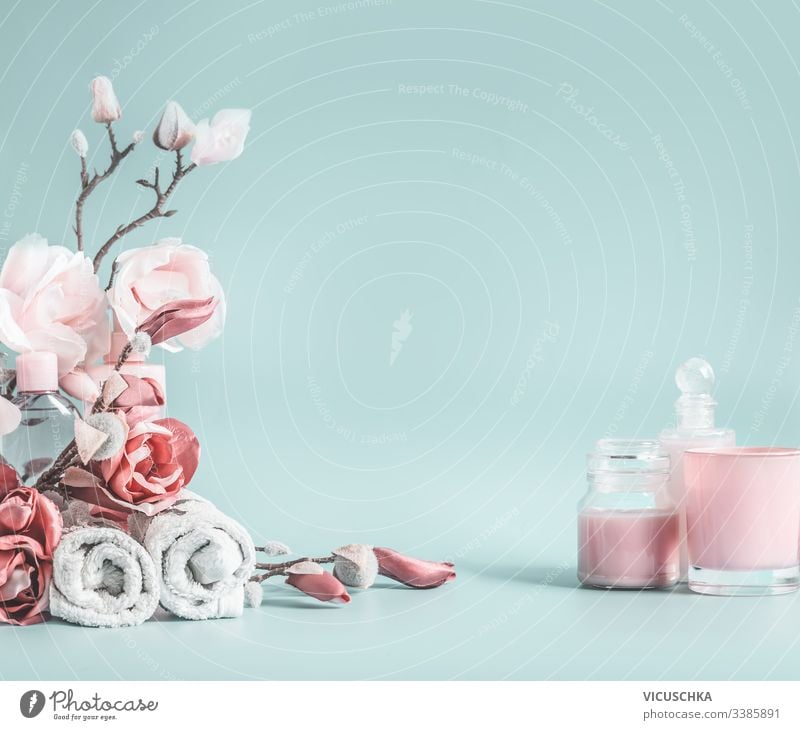 Schöner Hintergrund mit pastellrosa Blumen und Kosmetik auf pastellblauem Hintergrund Schönheitshintergrund Pastell Gesundheitswesen Schreibtisch modern blanko