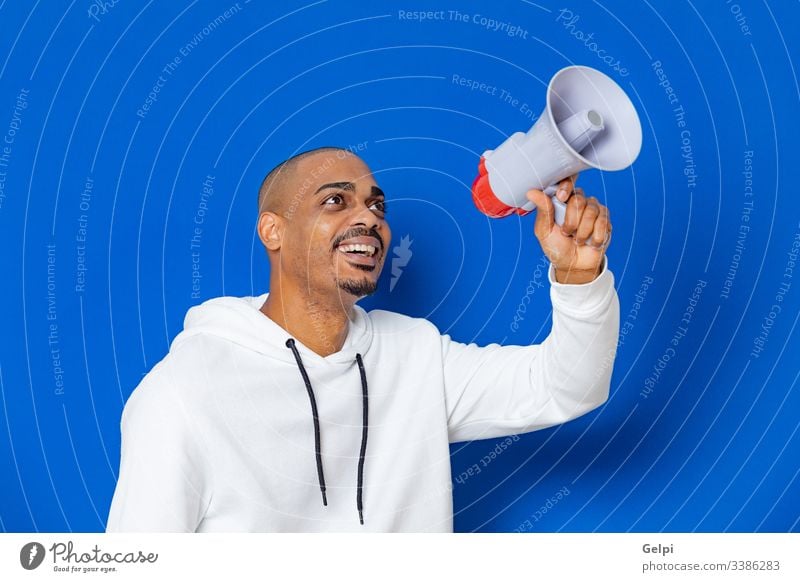 Afrikanischer Typ mit weißem Sweatshirt schwarz blau Megaphon Lautsprecher laut Redner Schreien ankündigen Stimme schreiend Kommunizieren Ankündigung Anzeige